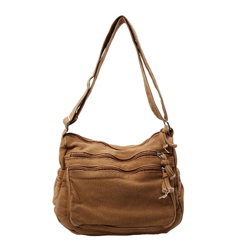 👜✨ Pojemna torba na ramię z płótna o efekcie postarzenia: wyróżnia się wielokomorową konstrukcją z zapięciami na suwak oraz szerokim, regulowanym paskiem.